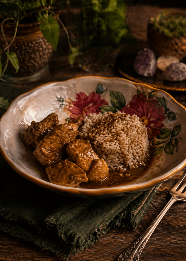 Dancing Chicken served over rice in a floral bowl on a wooden table